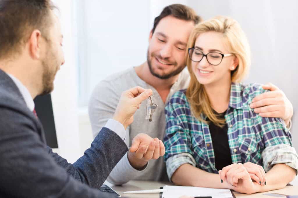 Couple receiving house keys by mortgage advisor after mortgage approval