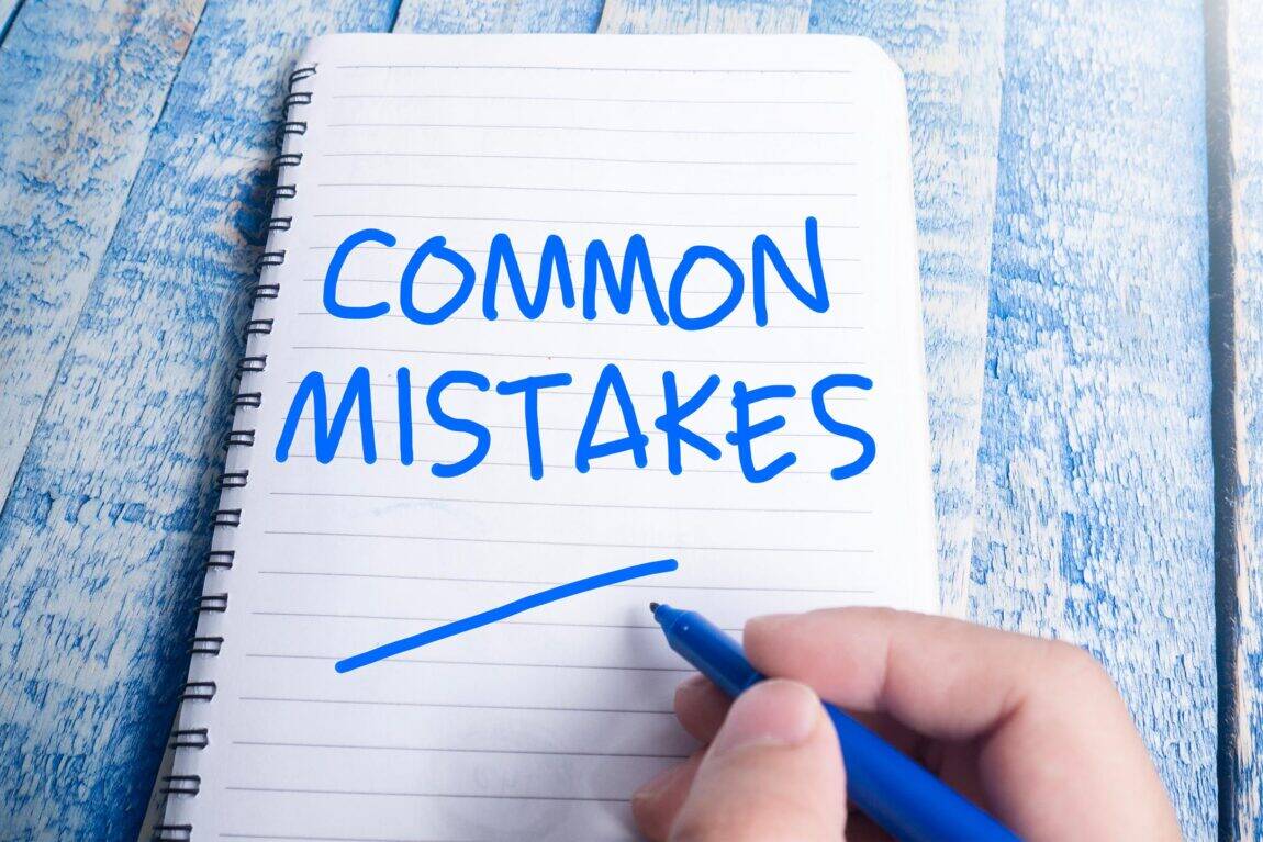 'Common mistakes' written in blue in on writing pad with hand holding the pen.